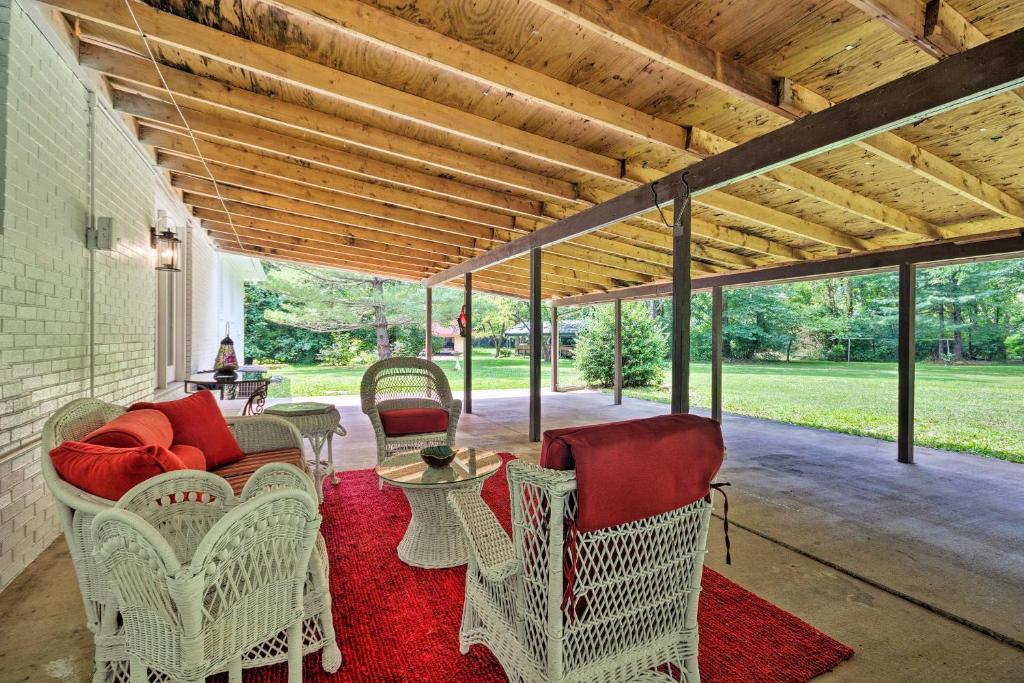 a porch with wicker chairs and a table on a red rug at Renovated Home on Watauga River, By Boat Ramp in Elizabethton