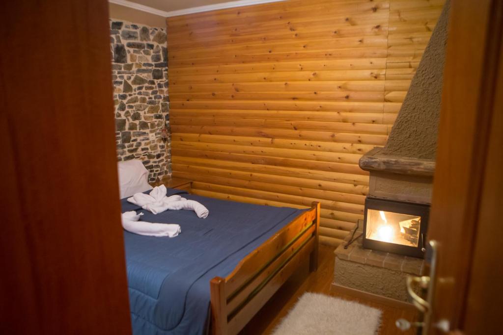 a room with a bed with a fireplace in it at Exohiko in Palaios Agios Athanasios