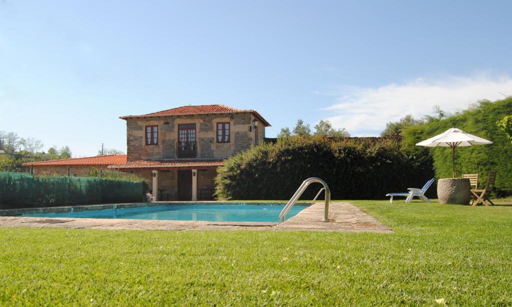 een zwembad in een tuin met een huis bij Casa de Sao Miguel Douro in Armamar