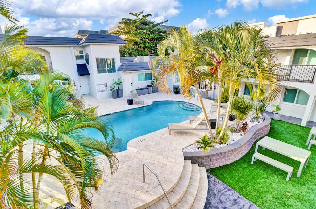 a backyard with a swimming pool and palm trees at RA suites in Pompano Beach