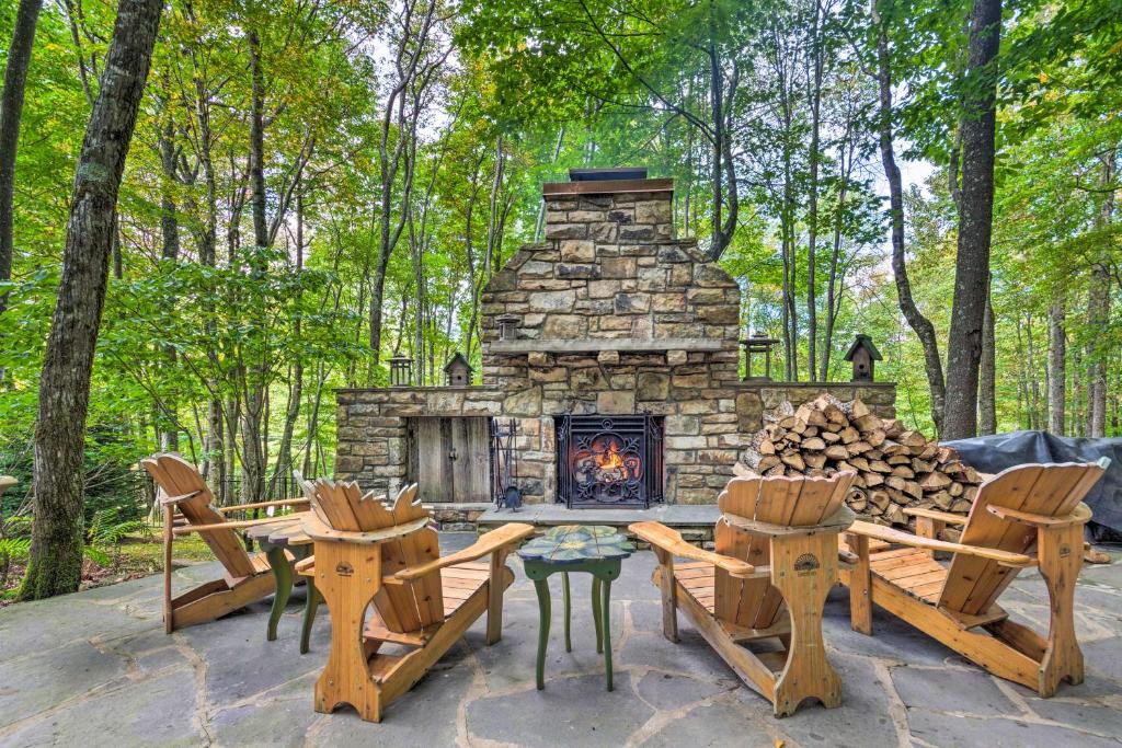 a stone fireplace in a yard with chairs and a table at Screened Porch and 3 Decks Beech Mountain Cabin in Beech Mountain