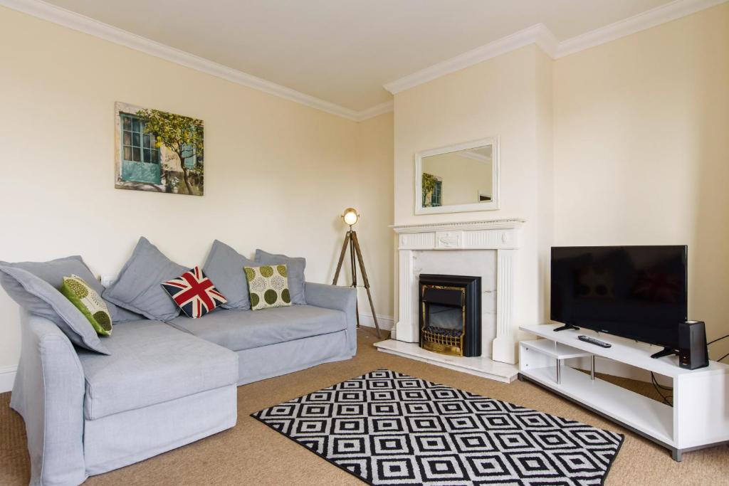 uma sala de estar com um sofá, uma televisão e uma lareira em Handpost View em Newport