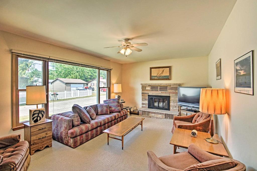 uma sala de estar com um sofá e uma lareira em Lake Huron House with Grill and Beach Access! em East Tawas
