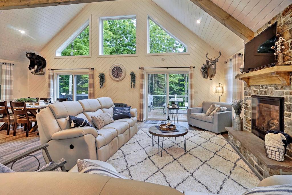 a living room with a couch and a fireplace at Benezette Cabin with Hot Tub, Grill and Mtn Views in Benezette