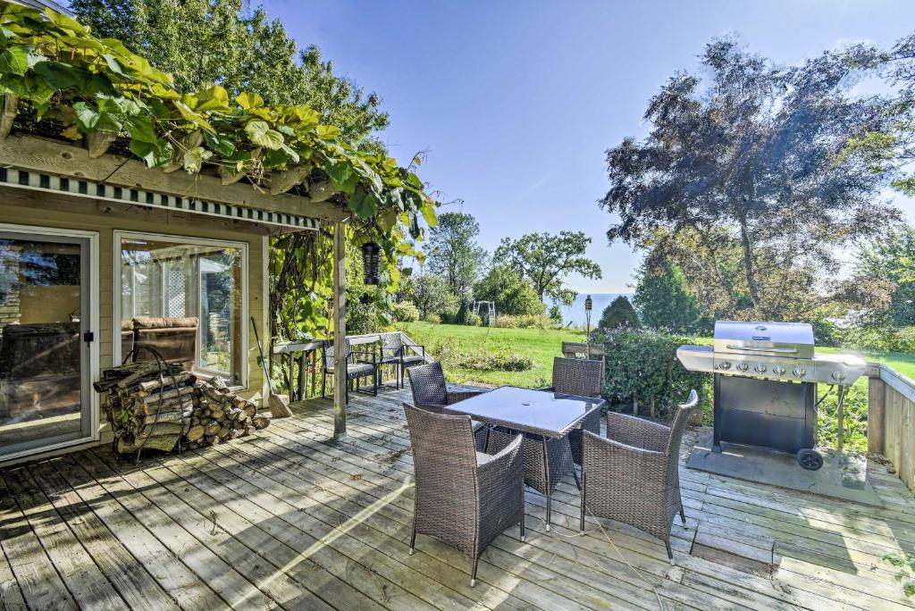 a patio with a table and chairs and a tv at Deck and Fire Pit Waterfront Lake Michigan Escape in Algoma