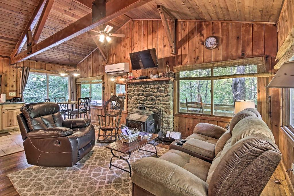 a living room with a couch and a fireplace at Secluded Stanardsville Cabin with 10 Acres and Hot Tub in Stanardsville
