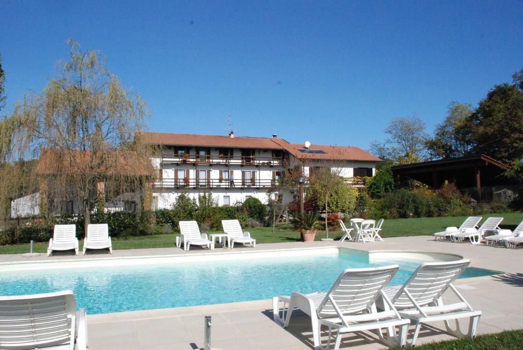 een groep stoelen en een zwembad met een gebouw bij Agriturismo Fano's Farm in Suno