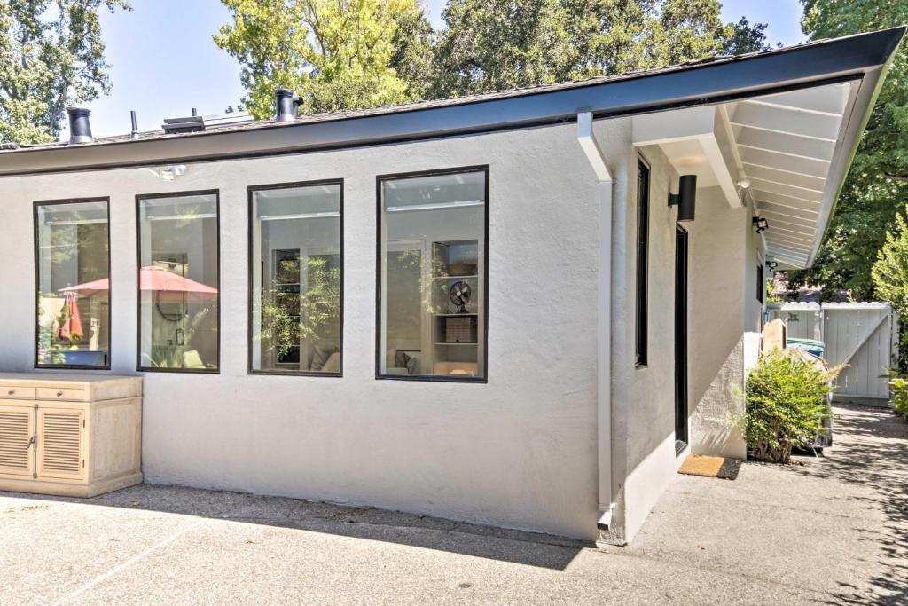 门洛帕克Menlo Park Studio about 2 Mi to Stanford University的一座白色的小建筑,设有窗户和雨伞