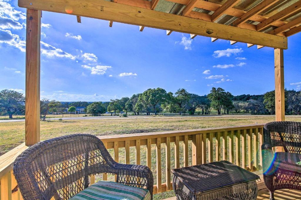 a porch with chairs and a table and a view of a field at Ranch Cabin with Decks, 10 Mi to Fredericksburg in Fredericksburg