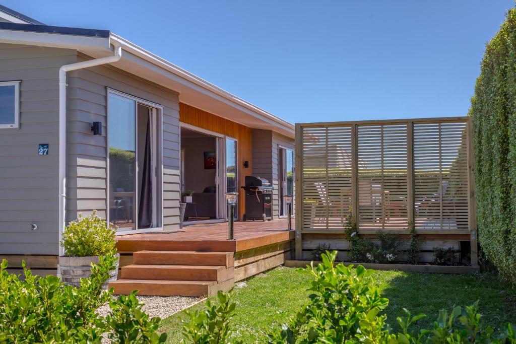 a home with a wooden deck and a house at 27 Tuscan in Martinborough 
