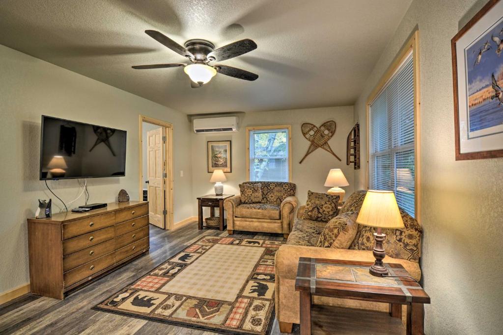 a living room with a couch and a ceiling fan at Petoskey Area Cabin, Walk to Crooked River! in Alanson