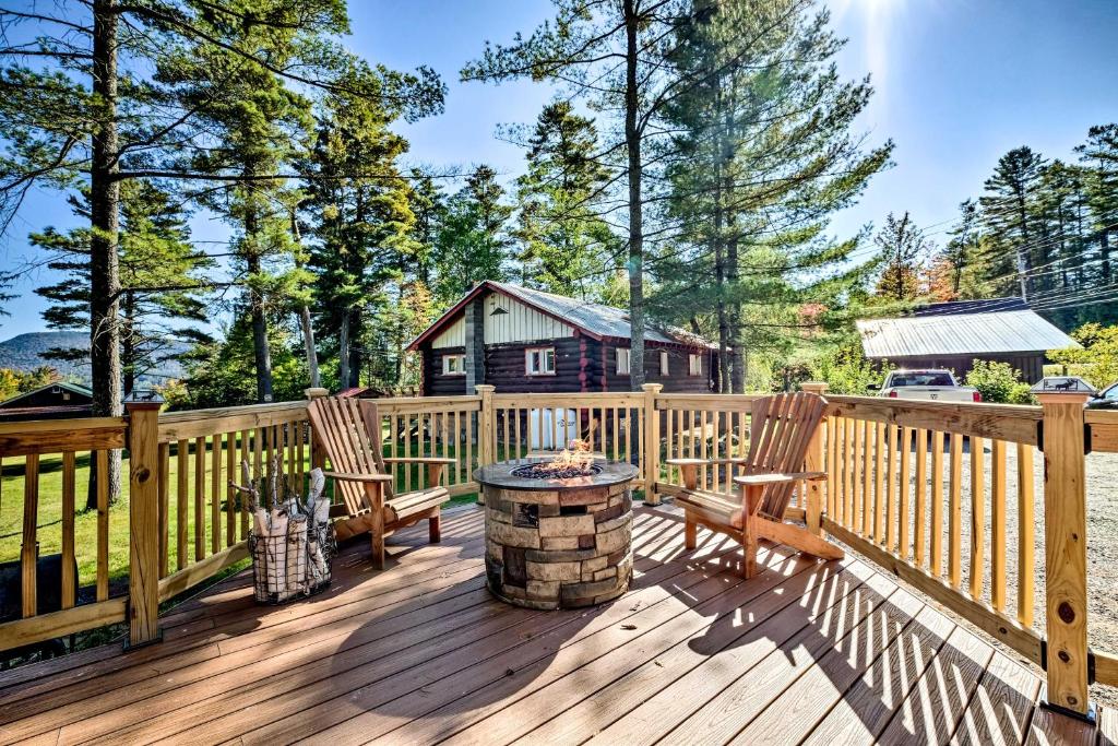 a deck with two chairs and a fire pit at Cozy Speculator Cottage about 2 Miles to Ski Resort! in Lake Pleasant