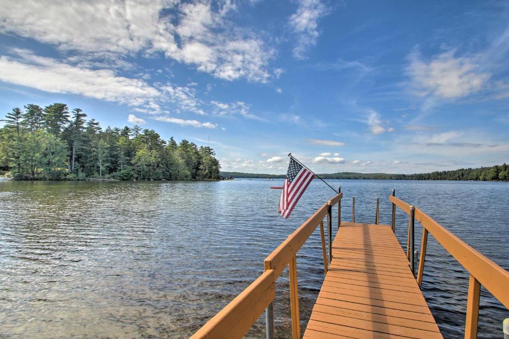 drapeau américain sur un quai sur un lac dans l'établissement Family Cabin with Beach Access on Panther Pond, à Raymond