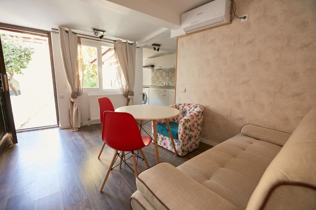 een woonkamer met een bank en een tafel bij Stanford Guesthouse in Boekarest