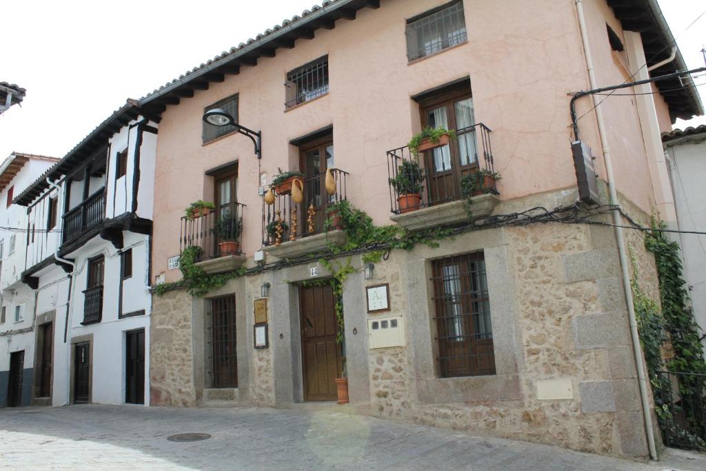 a stone building with balconies on a street at Apartamentos Rurales La Lancha in Aldeanueva de la Vera
