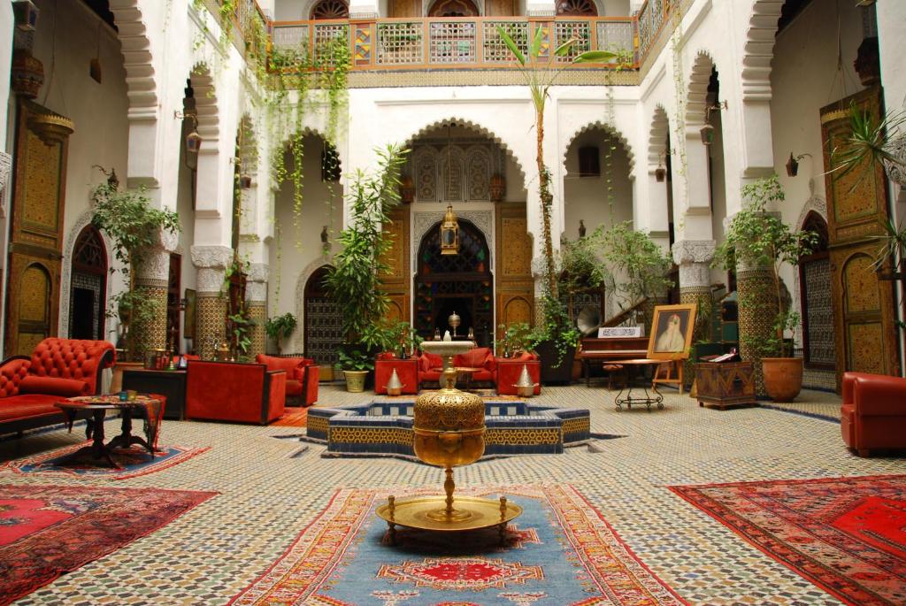 a large lobby with red chairs and a table at Dar El Ghalia in Fez
