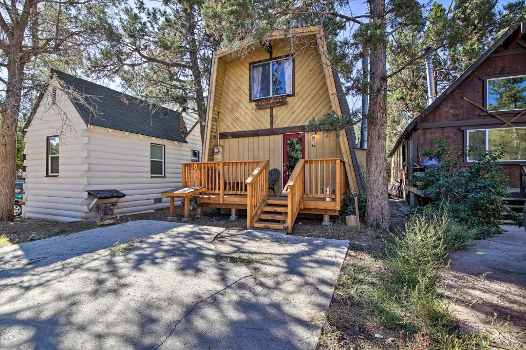 a house with two wooden benches in front of it at Log Cabin Retreat with Deck Near Big Bear Lake! in Big Bear City