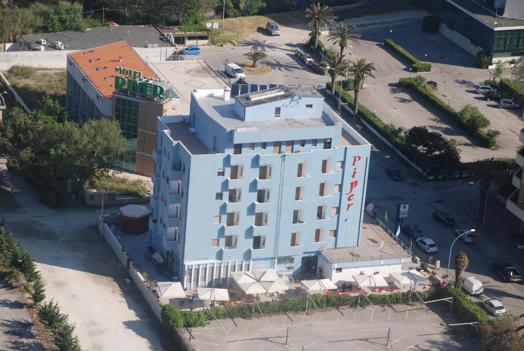 an overhead view of a white building with a parking lot at Hotel Piper & River in Montesilvano