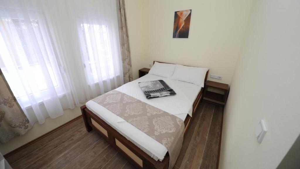 a small bedroom with a bed with a book on it at Hotel Rafaelo in Bosanska Dubica