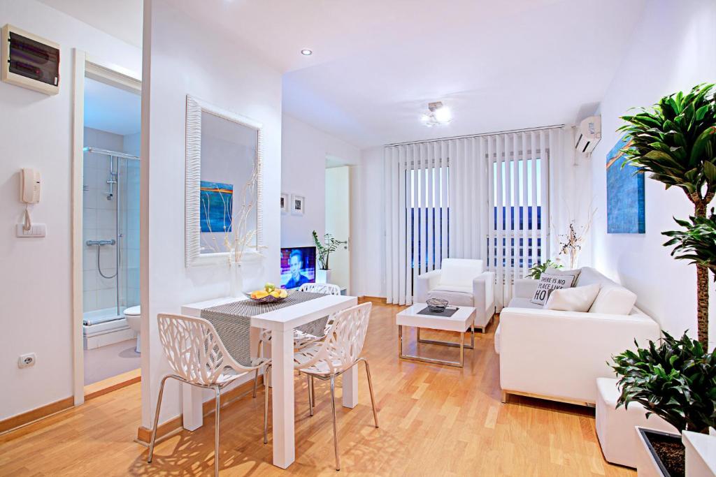 a white living room with a white table and chairs at Belville Luxury Apartment in Belgrade