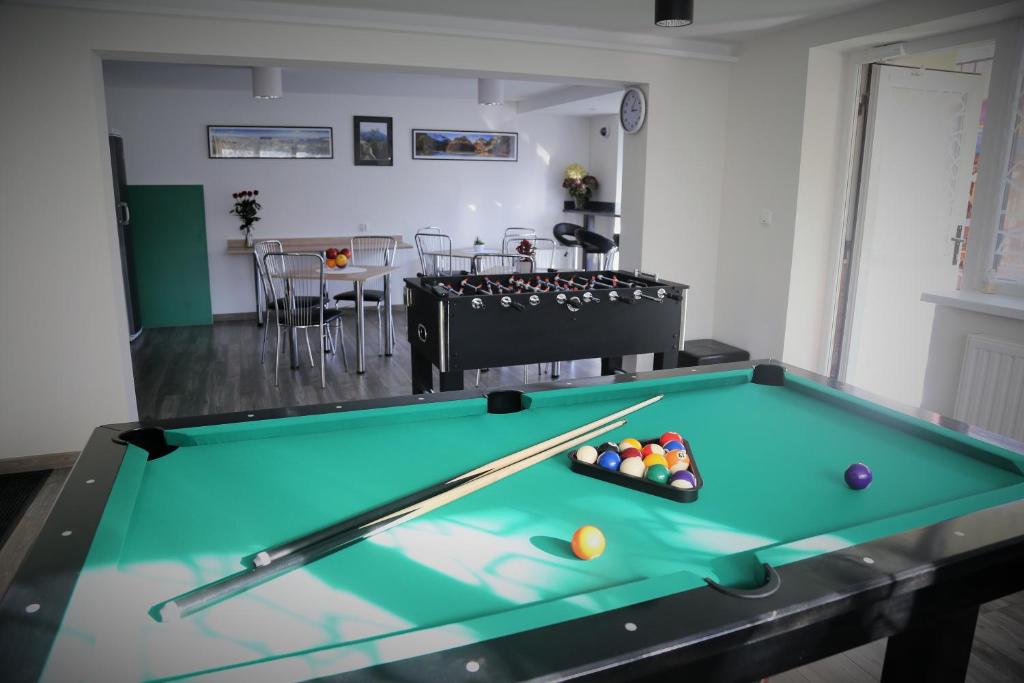 a pool table in a living room with a table at Willa Śnieżynka in Szczawnica