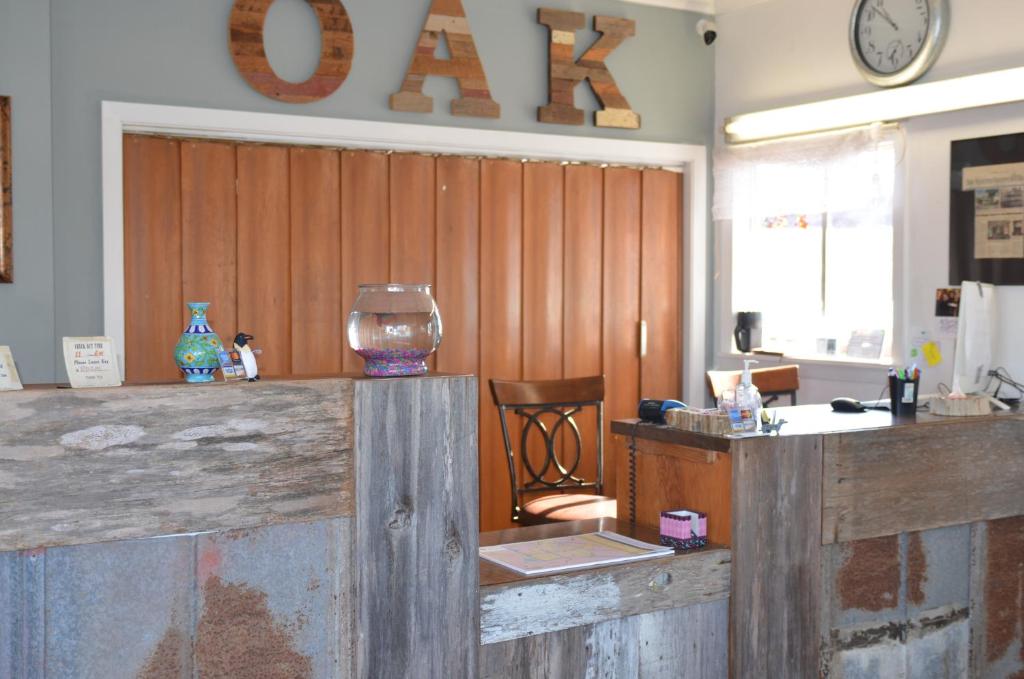 a room with a wooden wall with a desk and a clock at The Oak Motel in La Grange