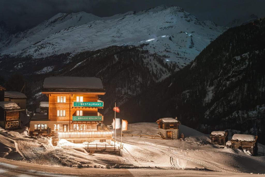 un edificio nella neve di fronte a una montagna di Aroleid Lodge a Zermatt