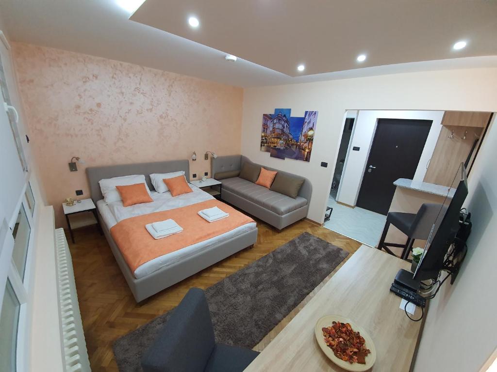 a small bedroom with a bed and a couch at Apartman DoDoLu in Belgrade