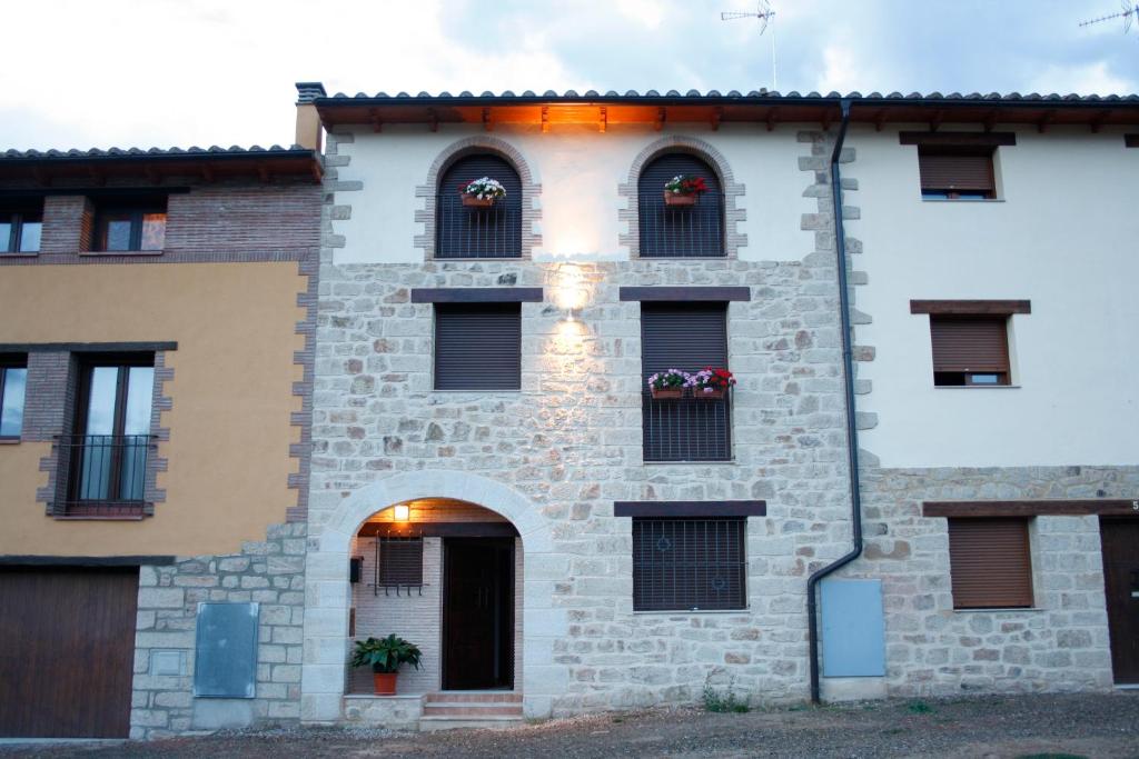 a building with flowers in the windows of it at Rosella de Rubielos in Fuentes de Rubielos