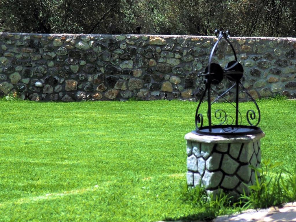 a bird bath sitting on top of a grass field at House of Garden in Dhráganon