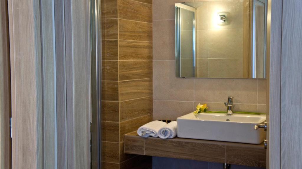 a bathroom with a sink and a mirror and towels at House of Garden in Dhráganon
