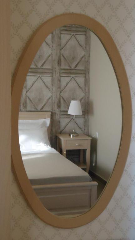 a bedroom with a bed and a round mirror at House of Garden in Dhráganon