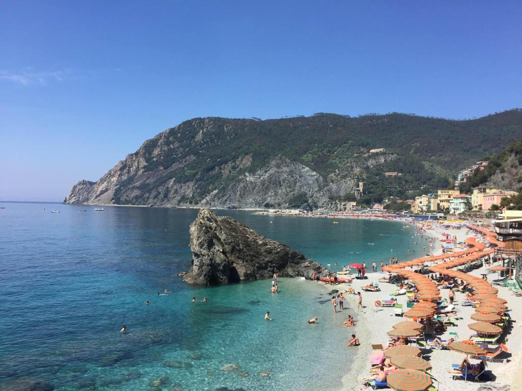 a beach with umbrellas and people in the water at Il Balconcino sul carugio in Monterosso al Mare