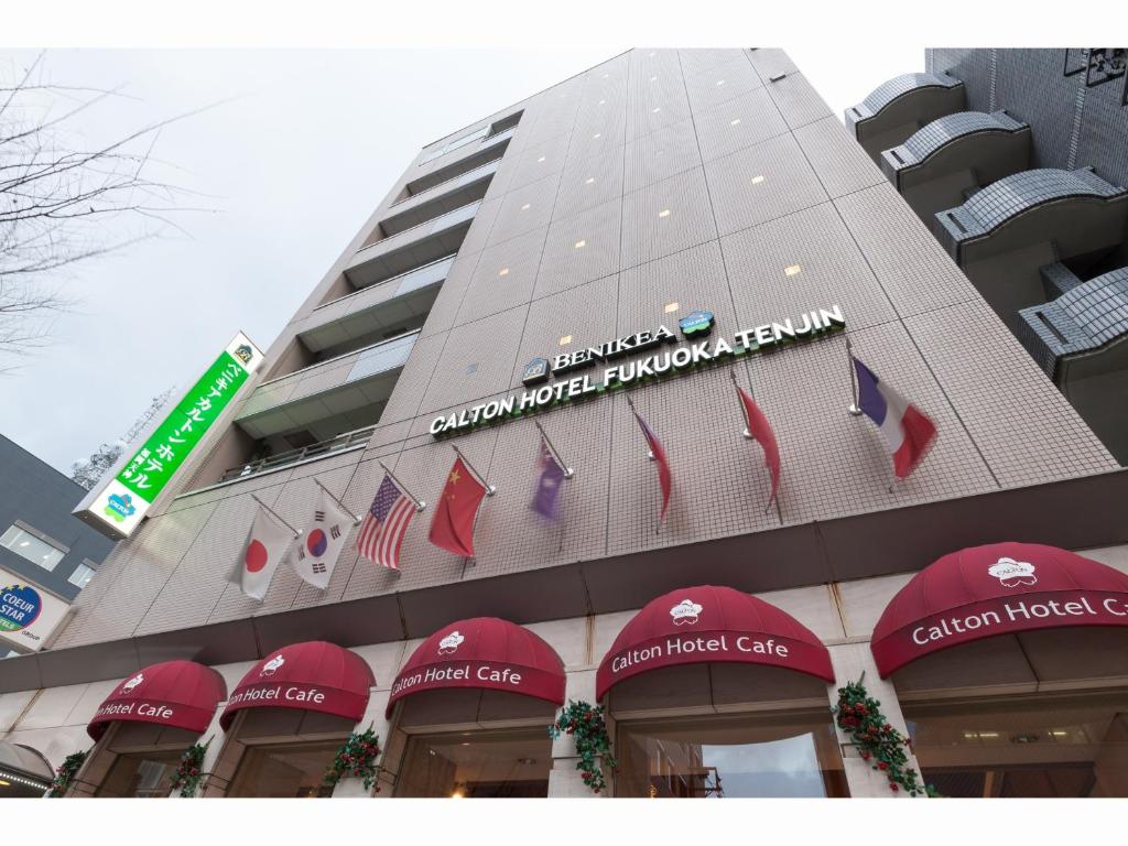 a building with red awnings on the side of it at Benikea Calton Hotel Fukuoka Tenjin in Fukuoka