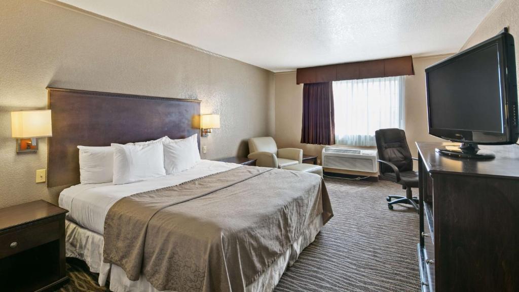 a hotel room with a bed and a flat screen tv at Best Western San Marcos in San Marcos