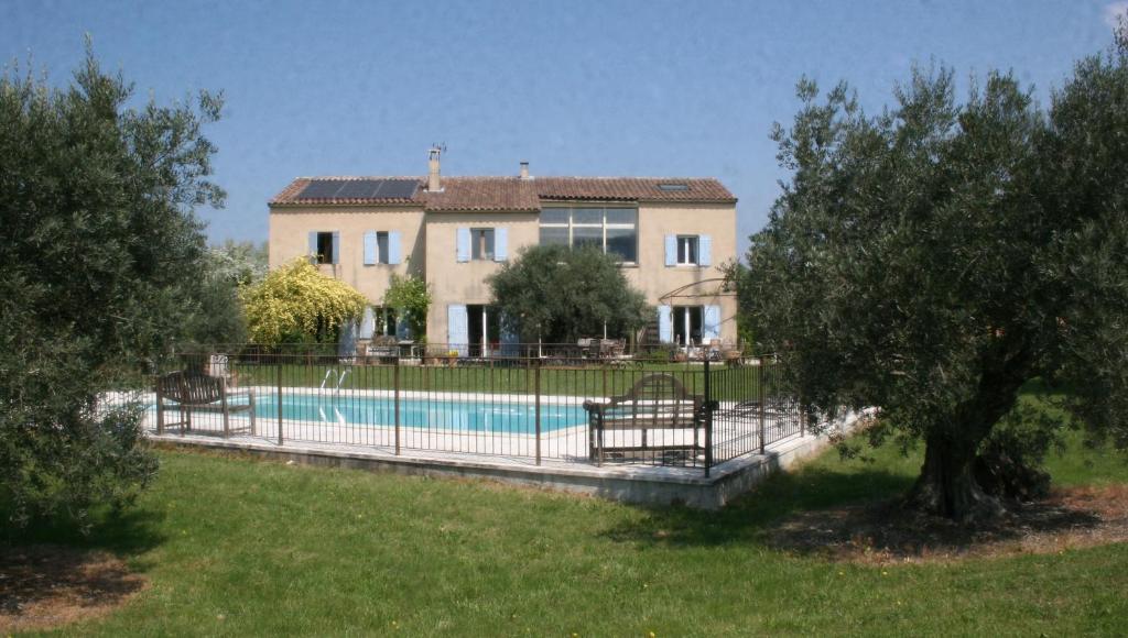 una casa con una valla alrededor de una piscina en Le Moulin de Felix, en Robion en Luberon