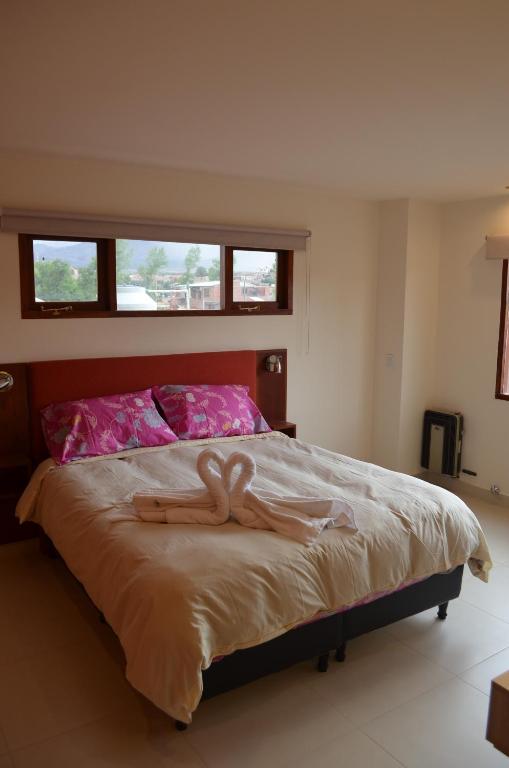 a bed with two wooden hearts on it at La Chakana Humahuaca in Humahuaca