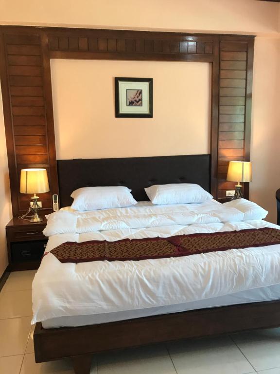 a large bed in a bedroom with two lamps at Sunny Beach View Guesthouse in Ka Rorn