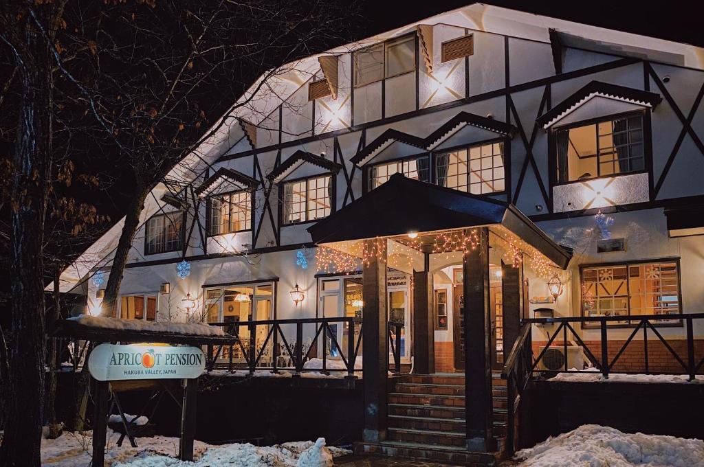 a large house is lit up at night at Apricot Pension in Hakuba