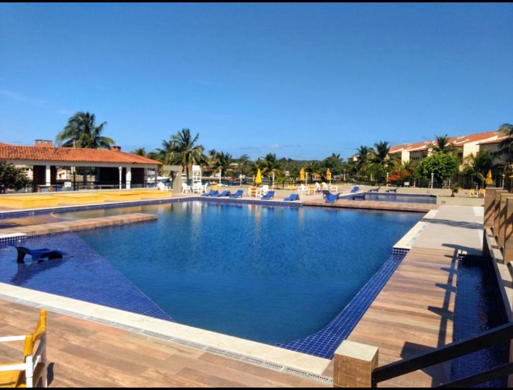 Una gran piscina con agua azul en un complejo turístico. en Condomínio Cabo Frio, en Cabo Frío