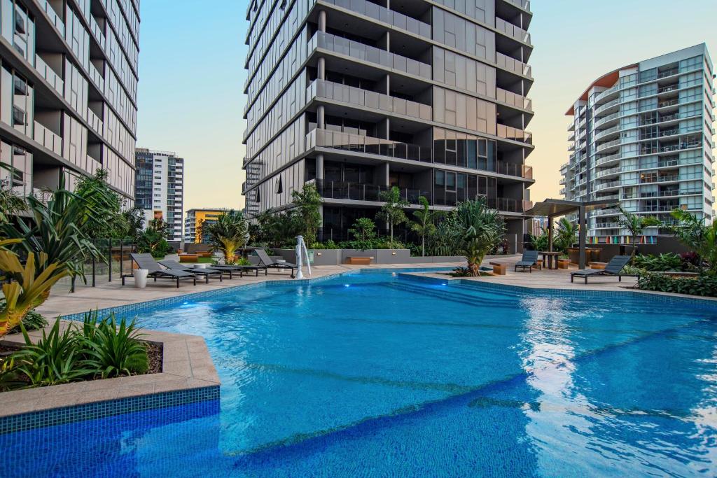 a large blue swimming pool with buildings in the background at Brisbane One Apartments by CLLIX in Brisbane
