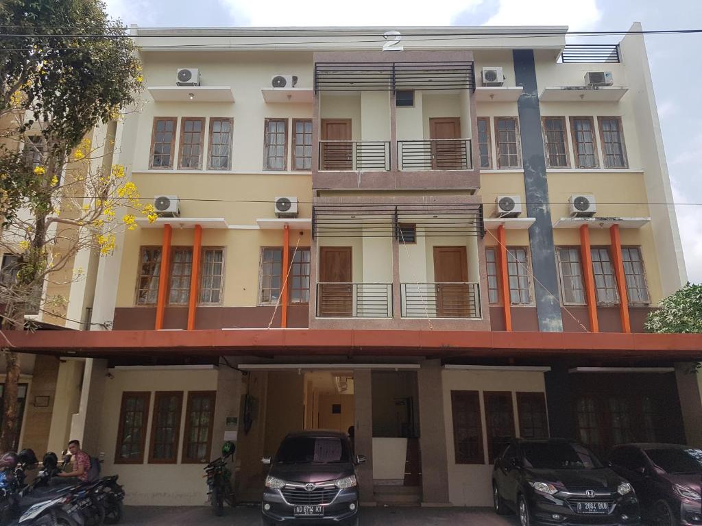 a building with cars parked in front of it at Residence Duksina 2 By SHM in Yogyakarta