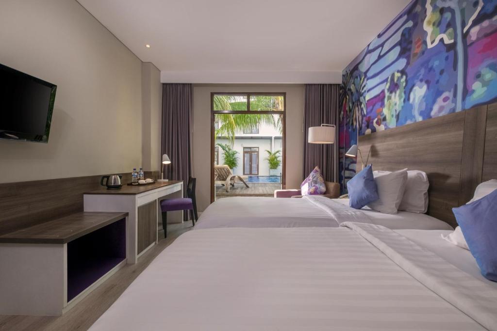 Un pat sau paturi într-o cameră la Wyndham Garden Kuta Beach Bali