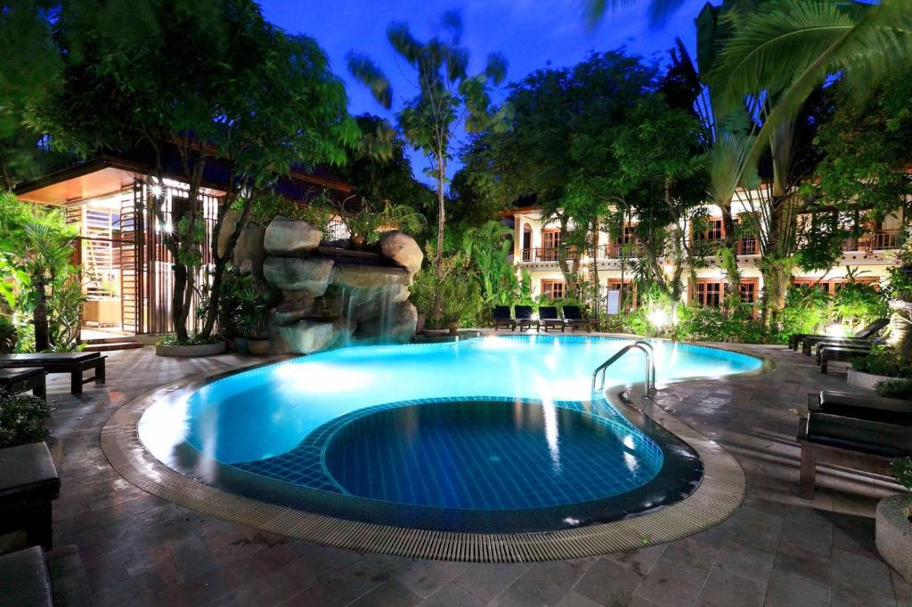 a swimming pool in a yard at night at Thai Palace Resort in Rawai Beach
