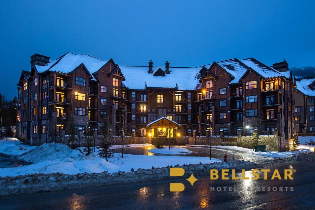 un grand bâtiment dans la neige la nuit dans l'établissement Glacier Mountaineer Lodge, à Golden
