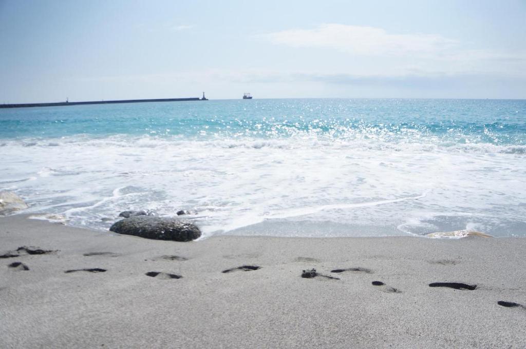 a beach with footprints in the sand and the ocean at HL Sea Homestay in Hualien City