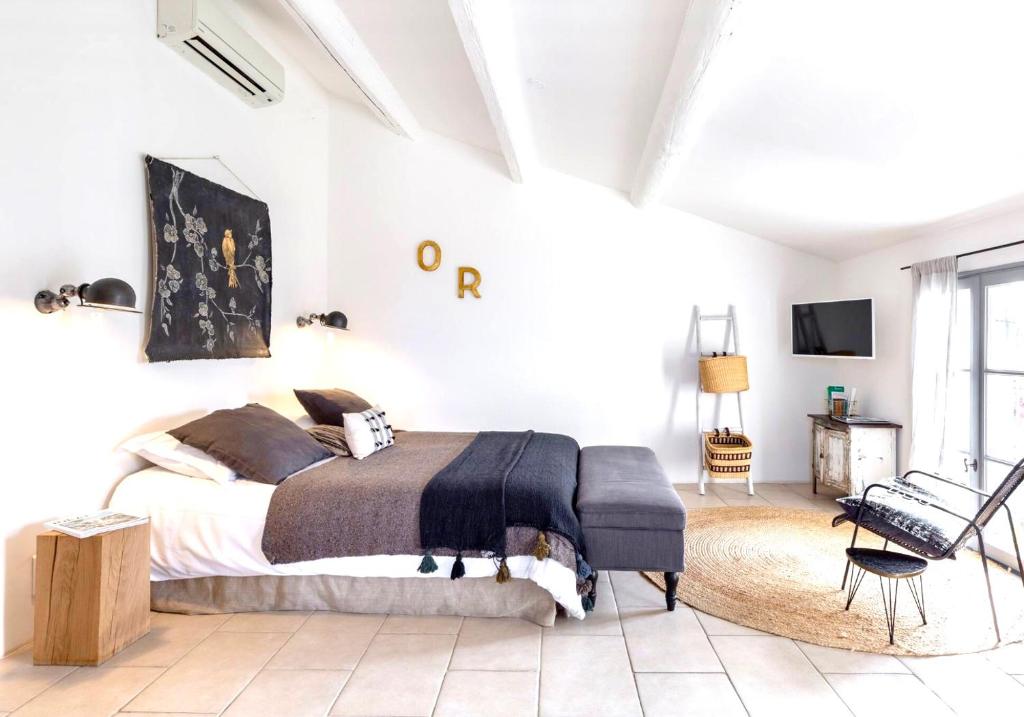 リル・シュル・ラ・ソルギュにあるSuite Sur La Sorgueの白いベッドルーム(ベッド1台、椅子付)