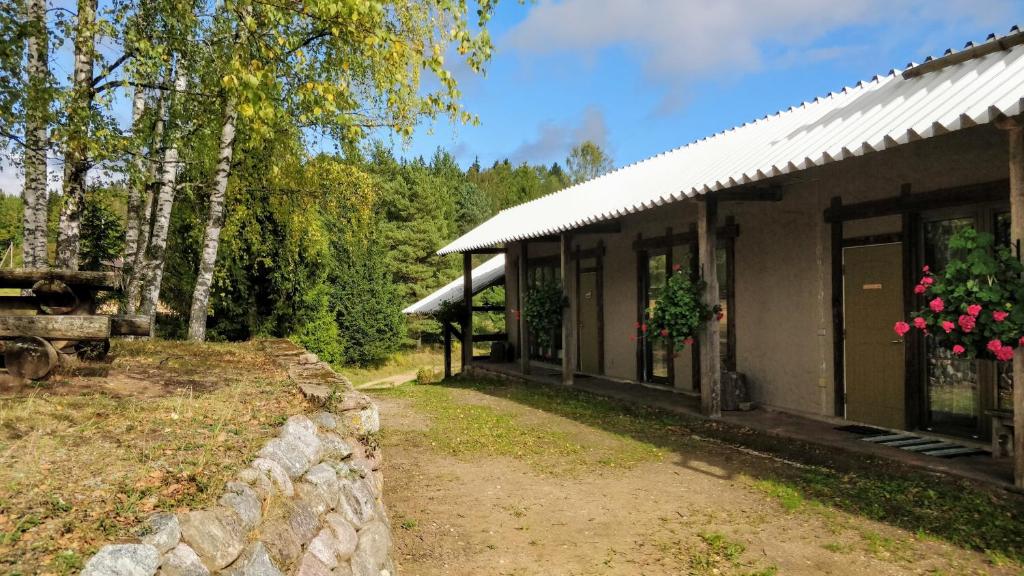 una casa con una pared de piedra junto a un edificio en Eha Farmstay, en Rõuge