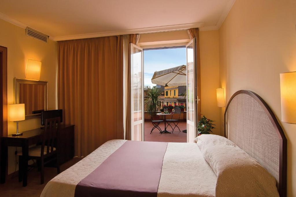 ローマにあるホテル ノヴェチェントのベッドとバルコニー付きのホテルルーム