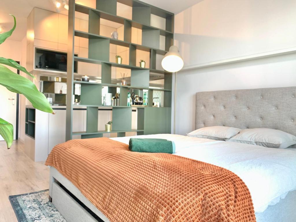 een slaapkamer met een groot bed met een groene plank bij Luxury, bright Studio with parking and balcony in Bratislava center in Bratislava